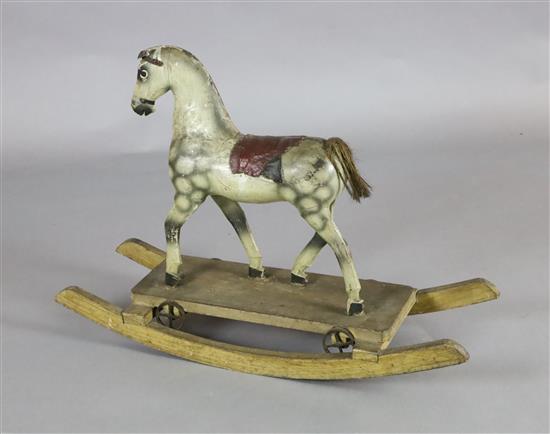 A rare Victorian carved and painted wood dapple grey rocking horse, W.31in. H.22in.